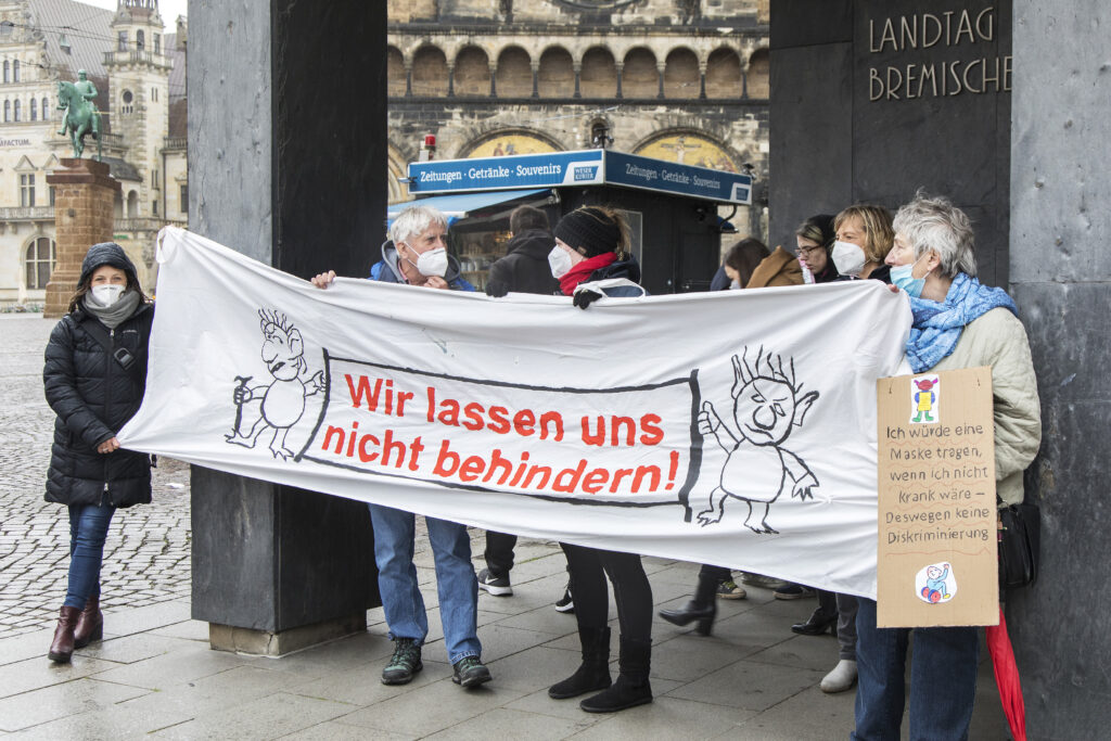 Menschen mit transparent vor dem Haus der Bremischen Bürgerschaft "Wir lassen uns nicht behindern"