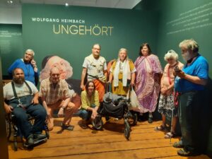 Florian Grams, Renate Domroeß, Gerald Wagner, Renate Horning, Tim Lovis, Heike Oldenburg, Bettina Fenzel, Monika Thein und Jürgen Karbe vor dem Selbstbildnis des gehörlosen Malers Wolfgang Heimbach zur Ausstellung "Ungehört".