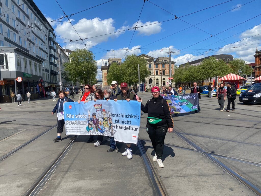 Der Demonstrationszug startet um 12.00 Uhr am Bremer Hauptbahnhof. Auf dem Transparent steht "Menschlichkeit ist nicht verhandelbar". Daneben ist ein Bild mit gezeichneten Menschen mit Behinderungen in Kleidung des 19. Jahrhunderts in einer Nachbildung des Gemäldes von Eugene Delacroix "Die Freiheit führt das Volk", auf dem ein Barrikadenkampf in der 2. Französischen Revolution Mitte des 19. Jahrhunderts gezeigt wird.