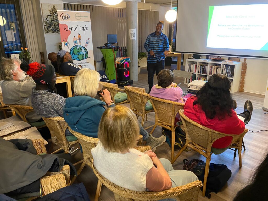 Mamadou Gayo Balde erklärt anhand einer Power Point Präsentation, worauf es beim Planen und Durchführen von erfolgreicher internationaler Zusammenarbeit ankommt.