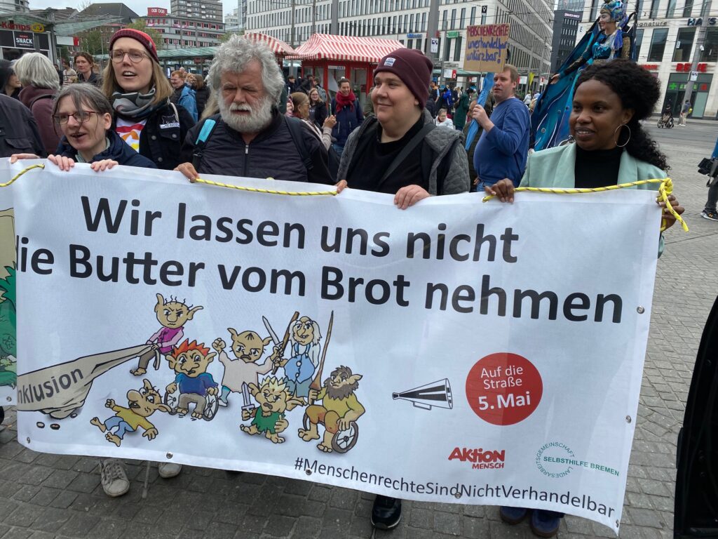 Victoria Rupnow, Fine Behrens, Jürgen Karbe, Christina Ladwig und Binta Bah tragen das diesjährige Motto-Banner "Wir lassen uns die Butter nicht vom Brot nehmen".